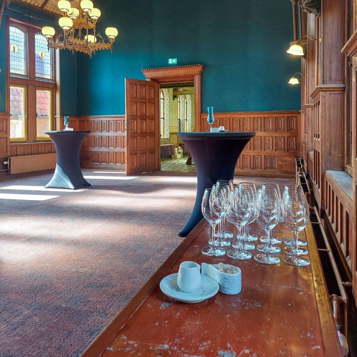 De Koffiekamer van Staatsman van binnen, gedekte statafels en een tafel met wijnglazen erop